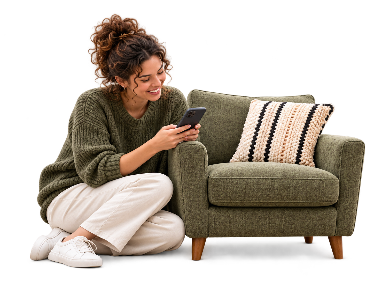 Woman seated close beside an olive armchair, holding her phone to prepare its listing